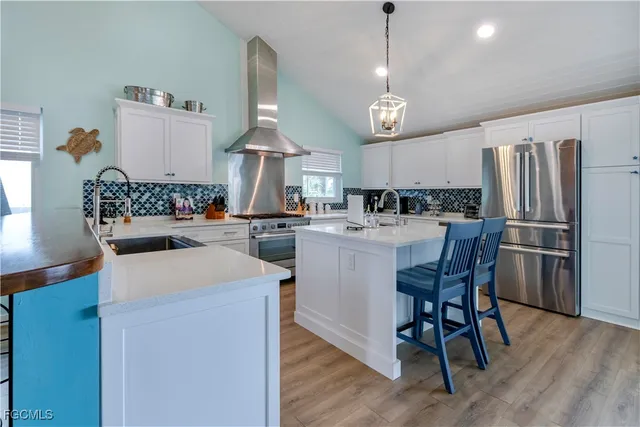 a kitchen with a dining table chairs appliances and cabinets