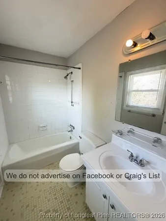 a bathroom with a granite countertop bathtub sink vanity and toilet