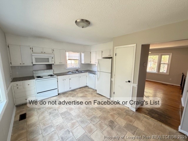 563 Alleghany Road Fayetteville, NC 28304 - Photo 4 of 15 a kitchen with granite countertop a refrigerator and white cabinets
