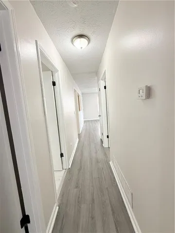 a view of a hallway with wooden floor and staircase