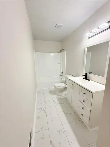 a bathroom with a double vanity sink a toilet and a bathtub