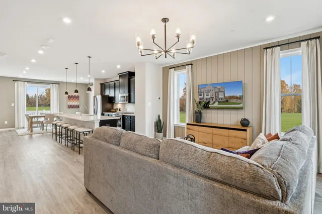 a living room with furniture a chandelier and a large window