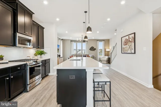 a large kitchen with stainless steel appliances granite countertop a stove and a wooden floors