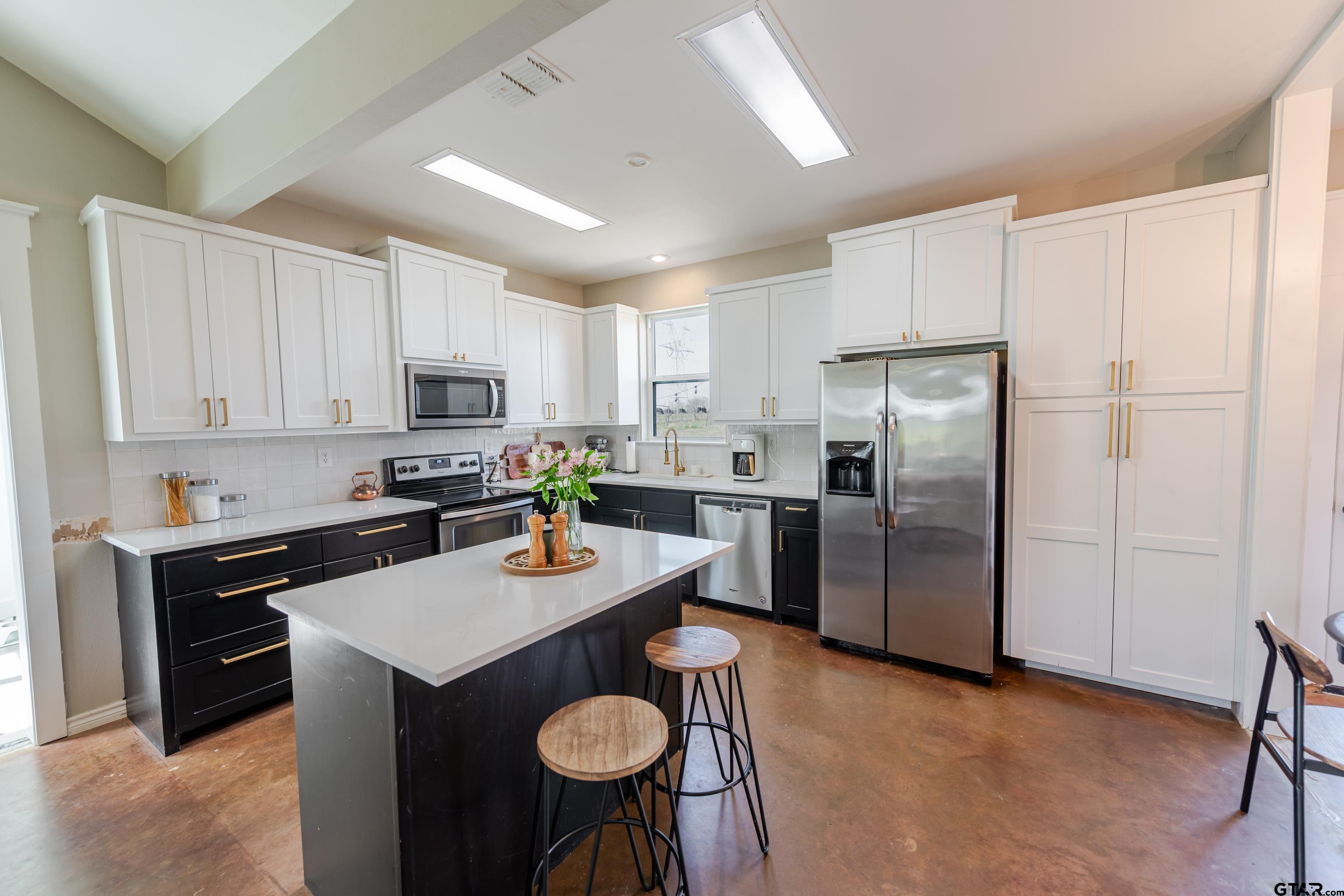 130 County Rd NW 1019 Mount Vernon, TX 75457 - Photo 3 of 17 a kitchen with stainless steel appliances granite countertop a sink a stove a refrigerator a center island and cabinets