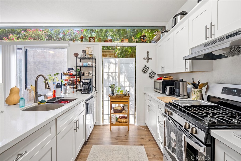 6865 Morro Road, Unit A Atascadero, CA 93422 - Photo 10 of 38 a kitchen with stainless steel appliances granite countertop a lot of cabinets and wooden floor