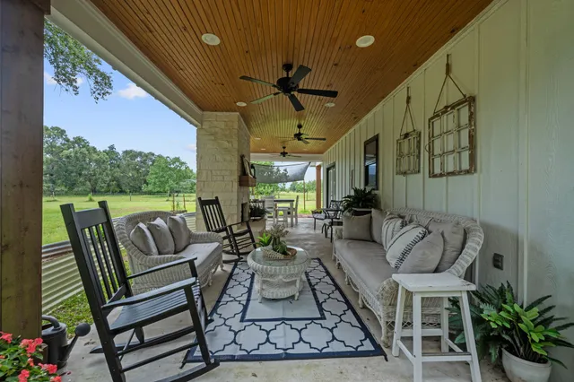 a view of a patio with couches table and chairs and potted plants