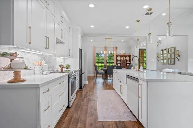 a large kitchen with stainless steel appliances kitchen island granite countertop a lot of counter space and a sink