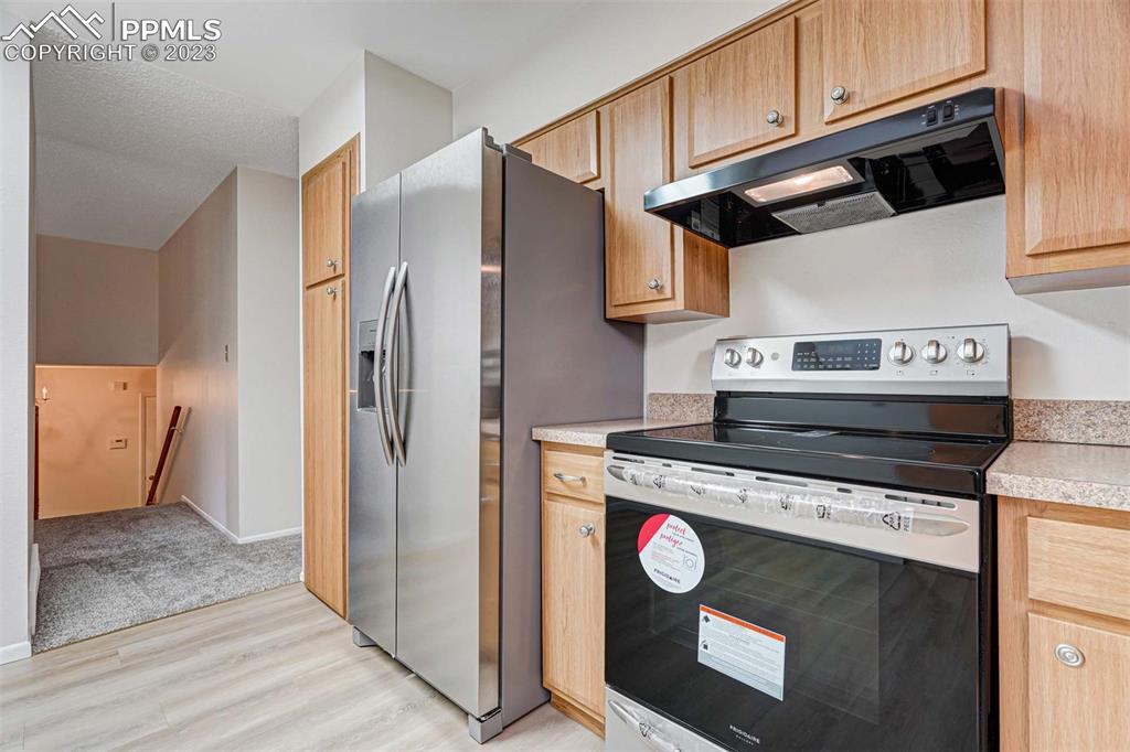 7228 River Bend Road Colorado Springs, CO 80911 - Photo 11 of 48 a kitchen with stainless steel appliances granite countertop a stove a refrigerator and a cabinets