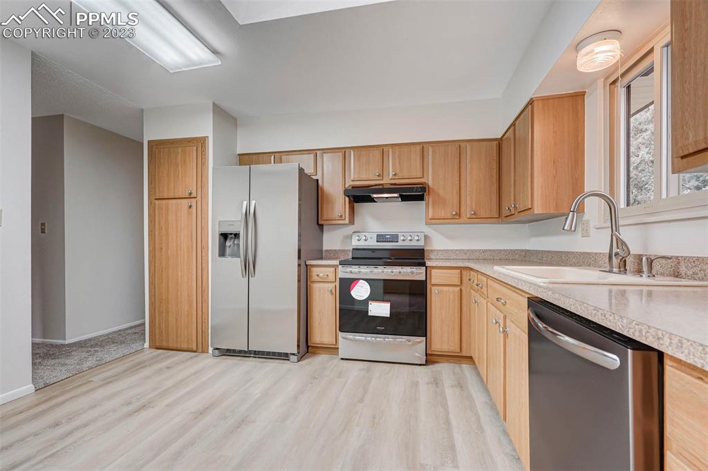 7228 River Bend Road Colorado Springs, CO 80911 - Photo 9 of 48 a kitchen with granite countertop a refrigerator and a sink