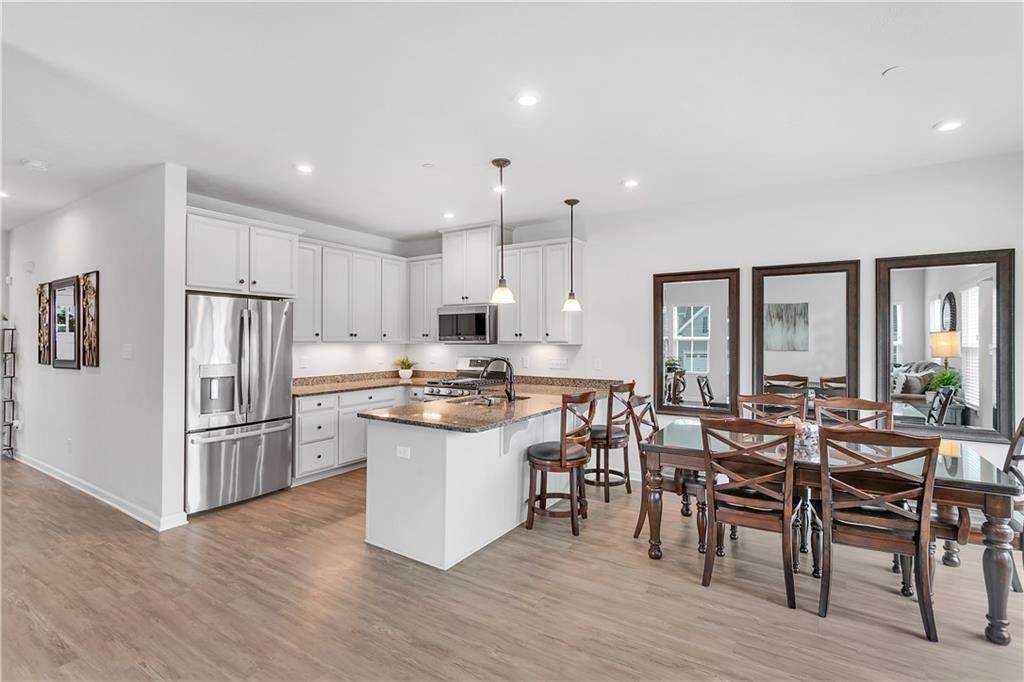 149 Providence Way Pittsburgh, PA 15234 - Photo 5 of 29 a kitchen with stainless steel appliances a dining table chairs stove refrigerator and microwave