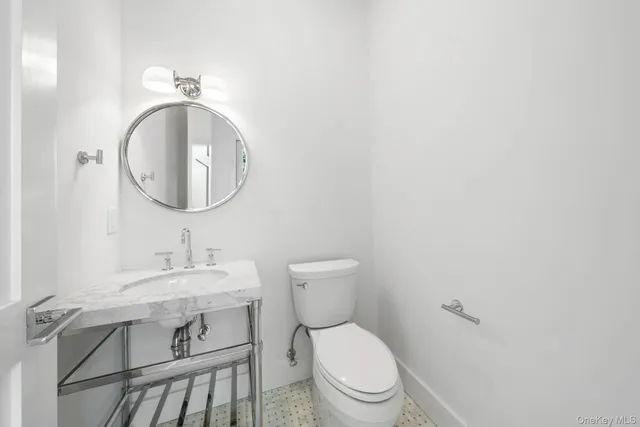 a bathroom with a toilet a sink and mirror