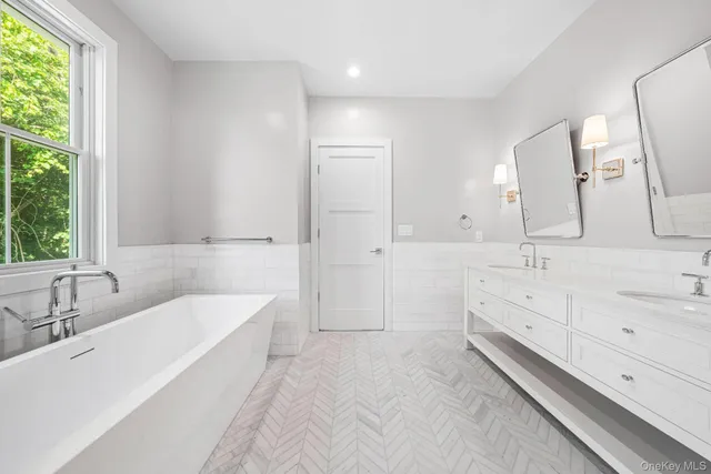 a bathroom with a double vanity sink a mirror and a bathtub