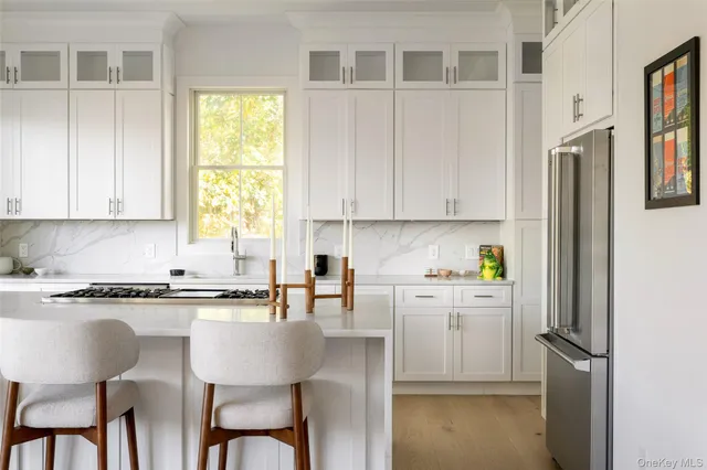 a kitchen with stainless steel appliances granite countertop a table chairs sink and cabinets
