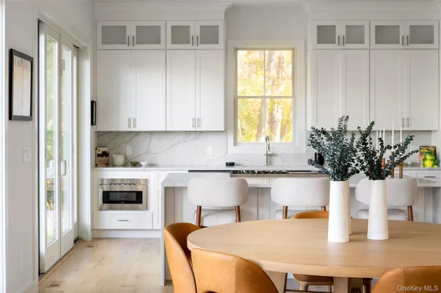 a kitchen with a table chairs and white cabinets