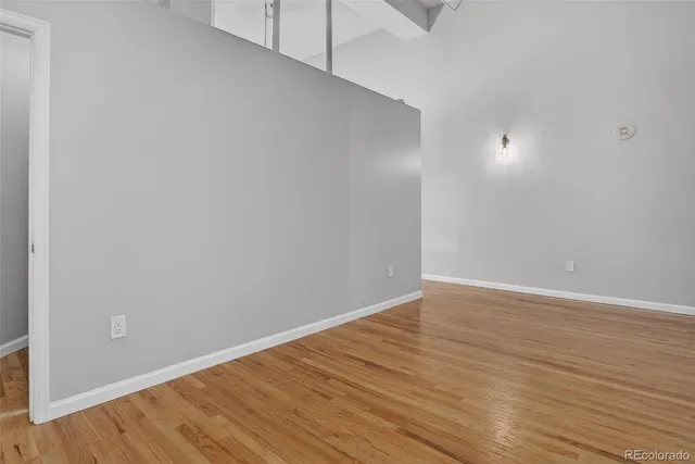 a view of an empty room with wooden floor