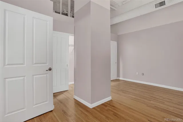 a view of an empty room with wooden floor