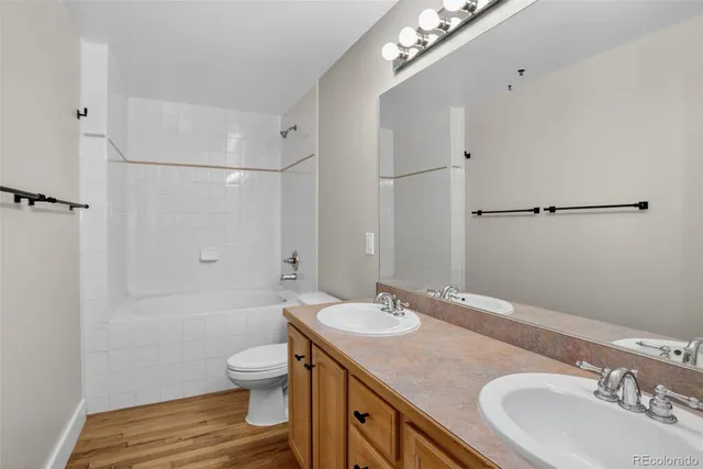 a bathroom with a granite countertop sink toilet a large mirror a shower and vanity