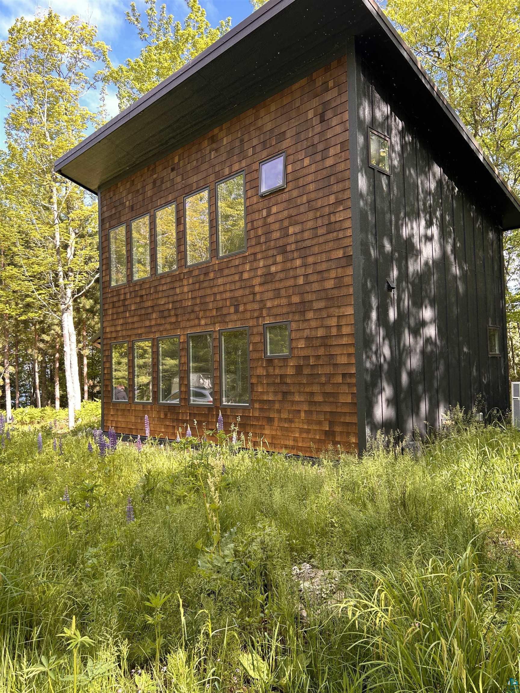 1596 North Shore Road La Pointe, WI 54850 - Photo 10 of 21 Contemporary architectural design featuring wood shingle siding and dark vertical paneling
