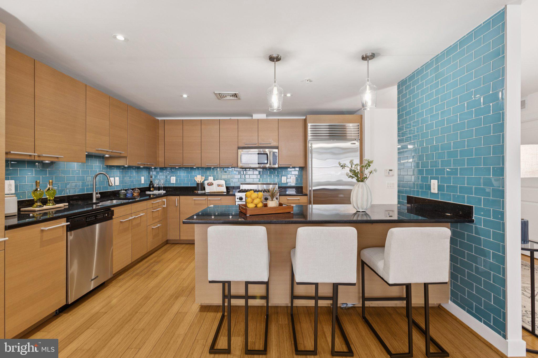 2425 L Street Northwest, Unit 210 Washington, DC 20037 - Photo 11 of 39 a kitchen with stainless steel appliances wooden cabinets a sink and a stove