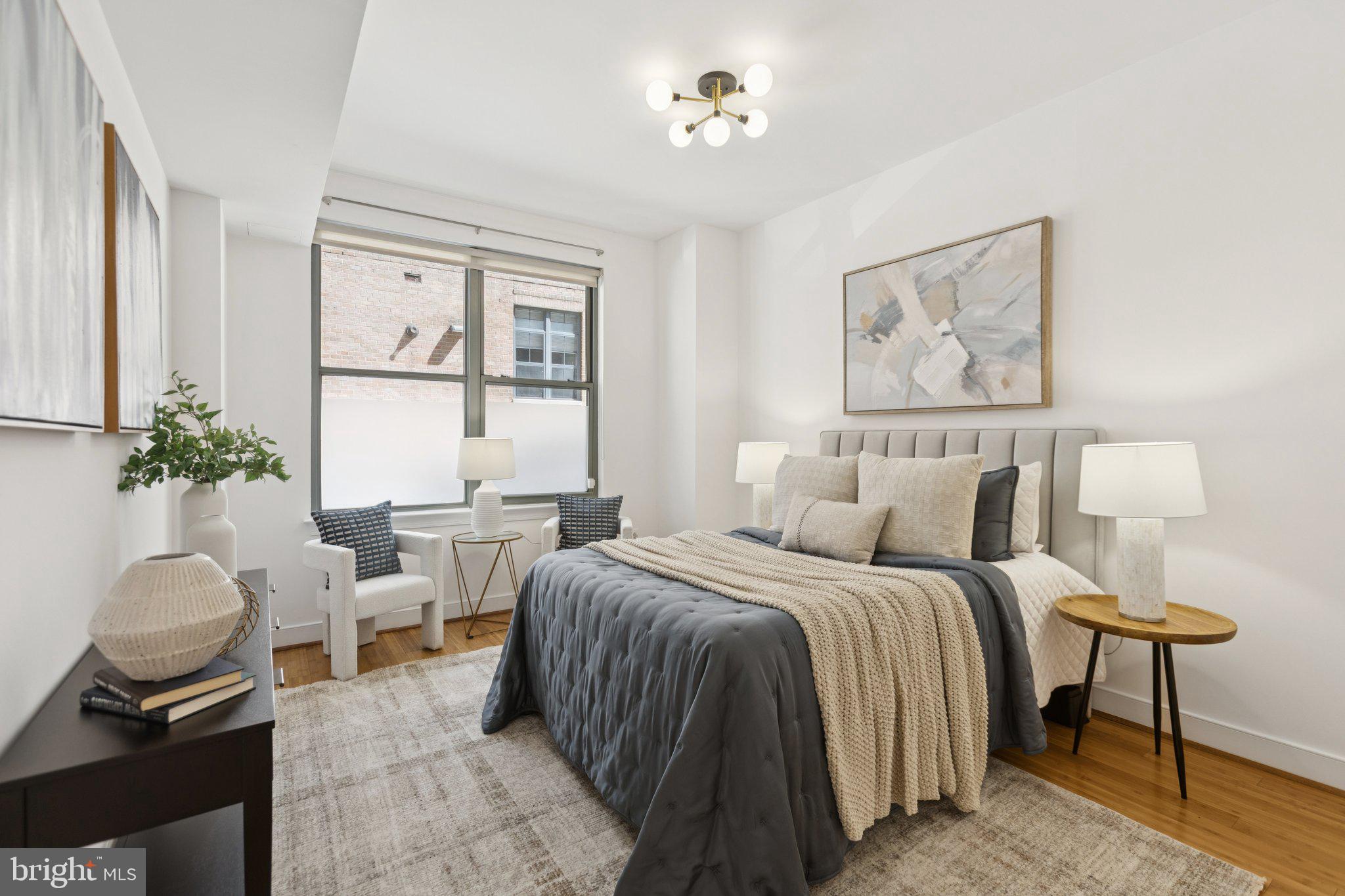 2425 L Street Northwest, Unit 210 Washington, DC 20037 - Photo 16 of 39 a bedroom with a bed and a chandelier