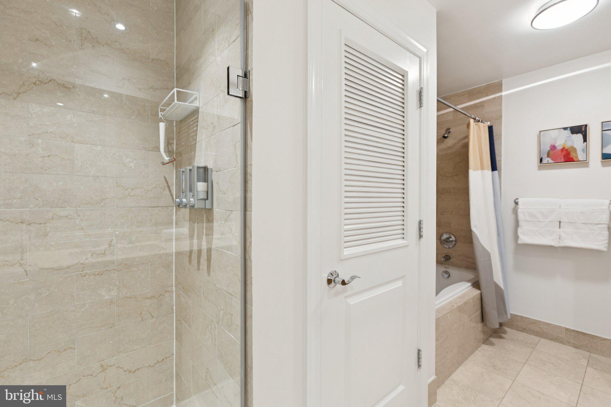 2425 L Street Northwest, Unit 210 Washington, DC 20037 - Photo 22 of 39 a bathroom with a bathtub and a shower