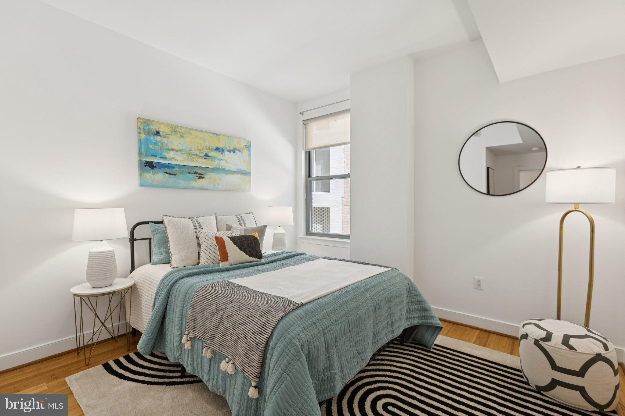 2425 L Street Northwest, Unit 210 Washington, DC 20037 - Photo 24 of 39 a bedroom with a bed and a painting on the wall