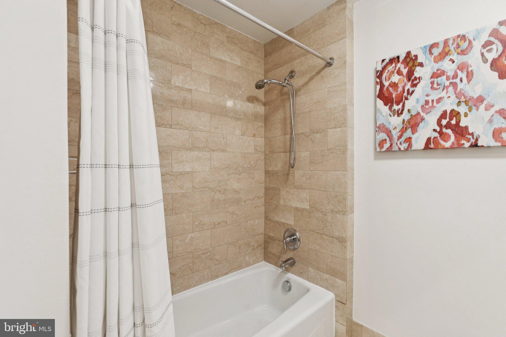 2425 L Street Northwest, Unit 210 Washington, DC 20037 - Photo 26 of 39 a bathroom with a bathtub and shower