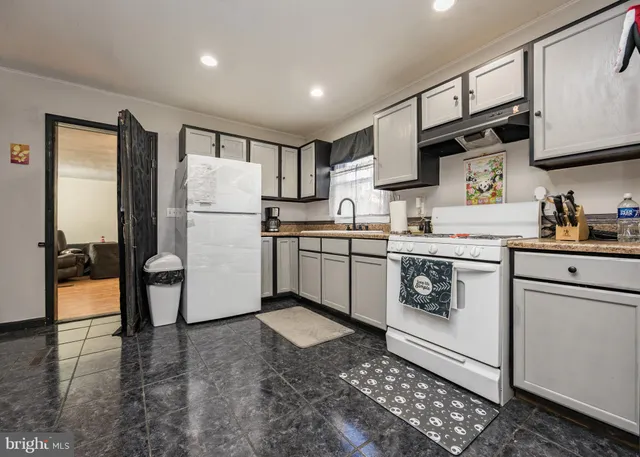 a view of a hallway with wooden floor and a bathroom