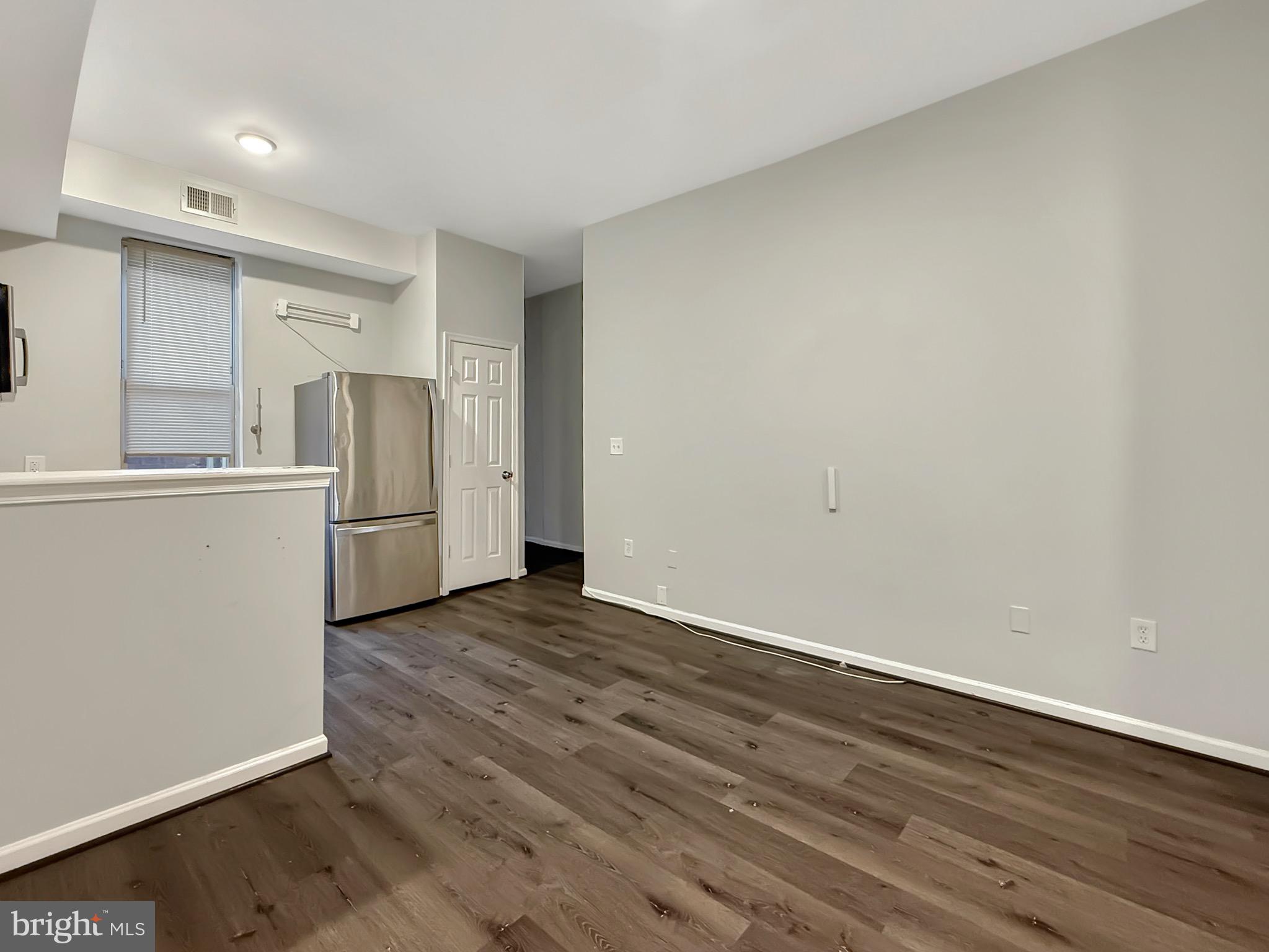 135 East North Avenue, Unit 2 Baltimore, MD 21202 - Photo 15 of 29 a view of empty room with wooden floor and refrigerator