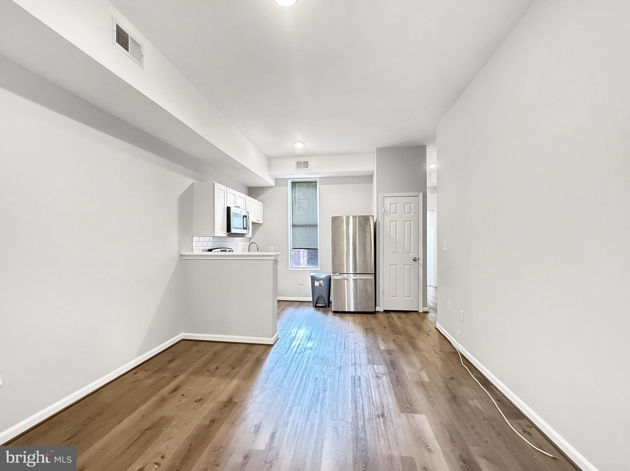 135 East North Avenue, Unit 2 Baltimore, MD 21202 - Photo 25 of 29 a view of a big room with wooden floor and windows