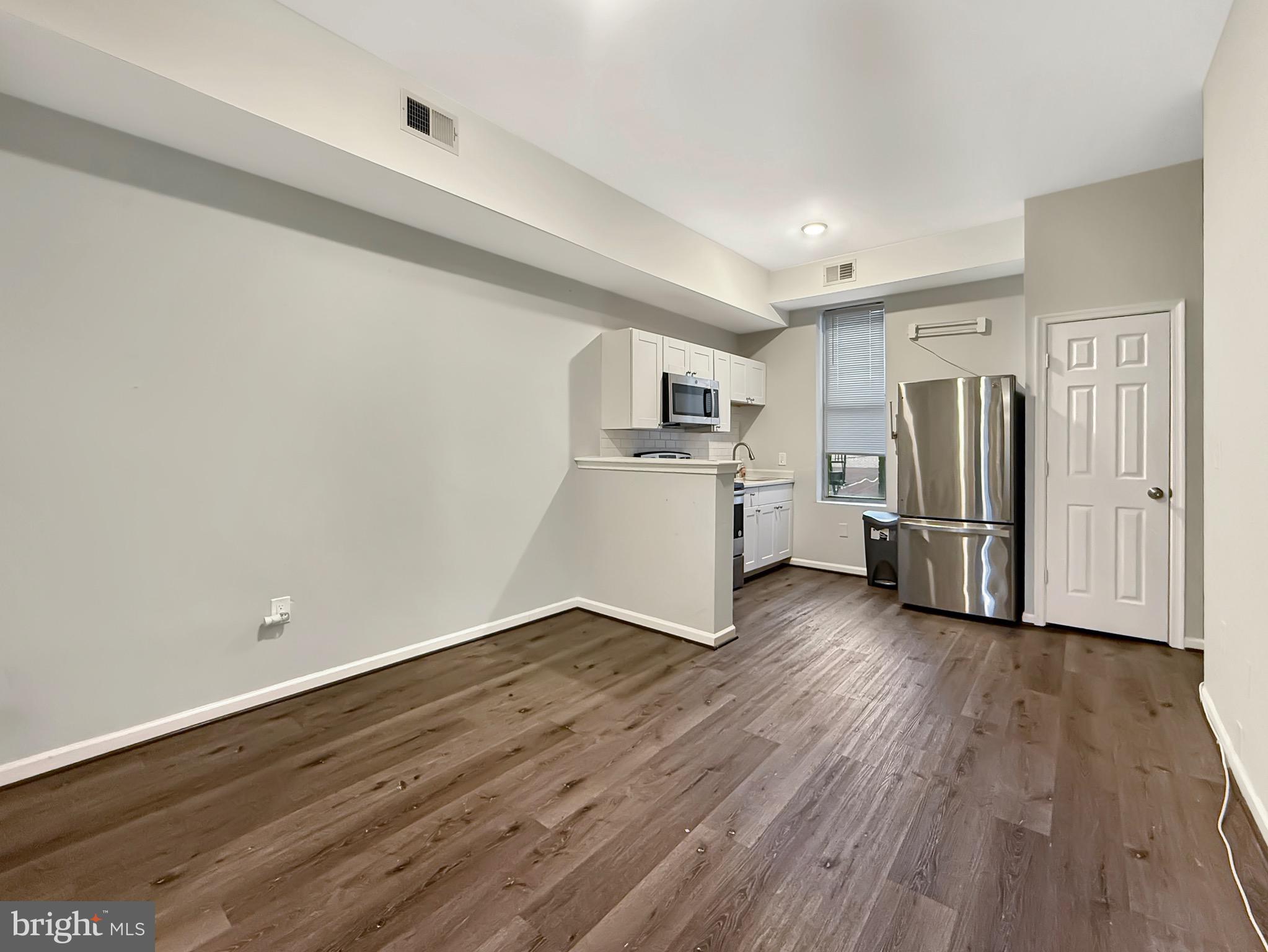 135 East North Avenue, Unit 2 Baltimore, MD 21202 - Photo 6 of 29 a view of a kitchen with a refrigerator a stove top oven