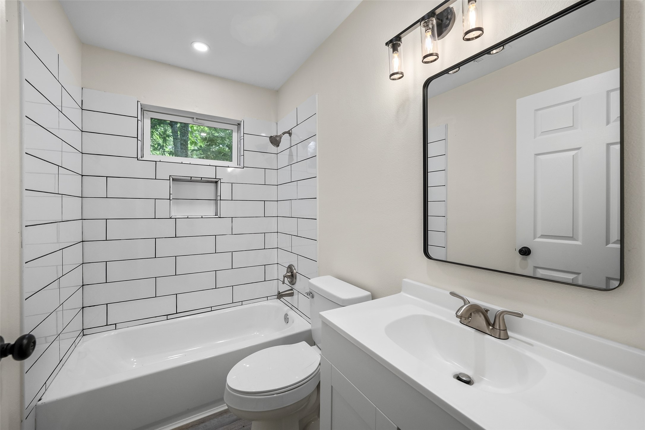 725 Lafayette Street Hempstead, TX 77445 - Photo 7 of 20 Updated full bathroom with modern subway tile surround, built-in shower niche, contemporary vanity, upgraded lighting, and designer finishes.