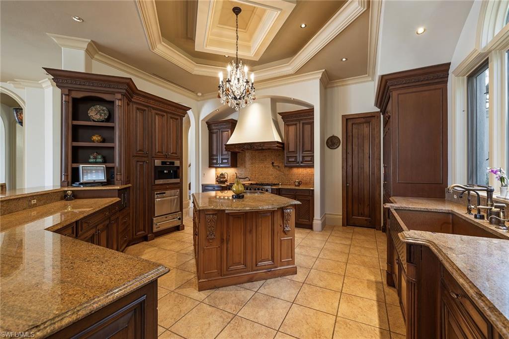 15167 Brolio Lane Naples, FL 34110 - Photo 11 of 50 a kitchen with stainless steel appliances granite countertop a sink and a refrigerator