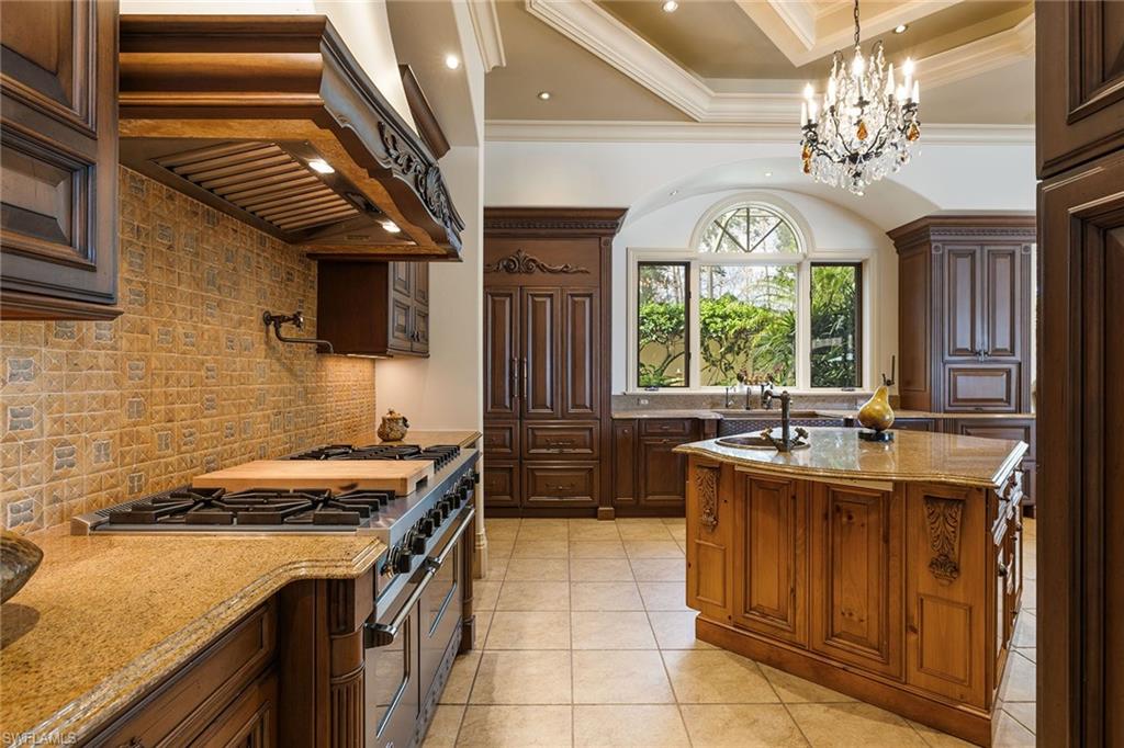 15167 Brolio Lane Naples, FL 34110 - Photo 13 of 50 a kitchen with a stove a sink a refrigerator and a dining table