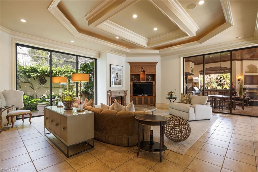 15167 Brolio Lane Naples, FL 34110 - Photo 14 of 50 a living room with patio furniture and a floor to ceiling window
