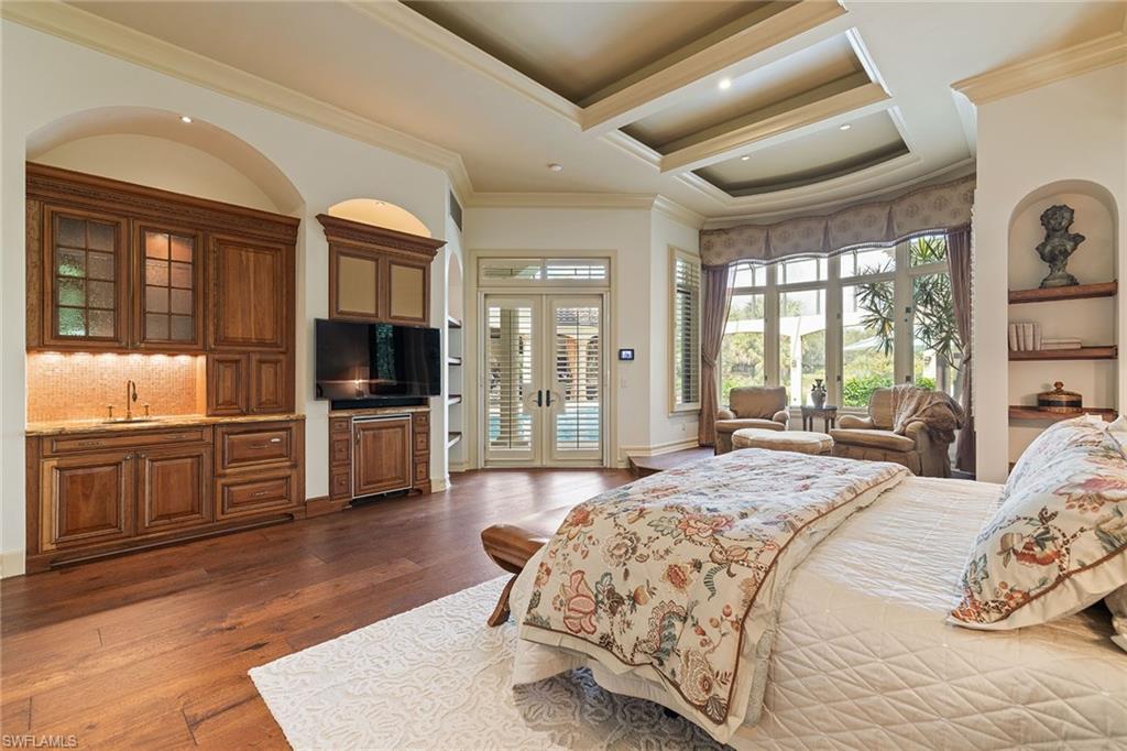15167 Brolio Lane Naples, FL 34110 - Photo 19 of 50 a spacious bedroom with a bed and wooden floor