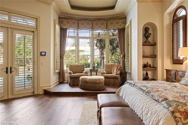 a spacious bedroom with a bed a fireplace and a large window