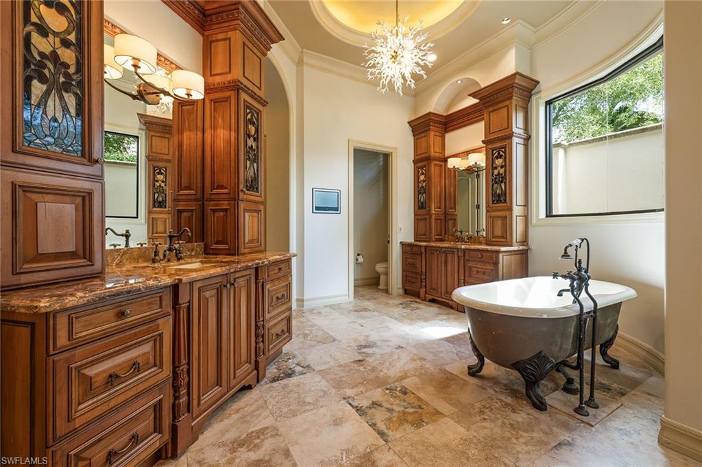 15167 Brolio Lane Naples, FL 34110 - Photo 22 of 50 a spacious bathroom with a double vanity sink and a mirror