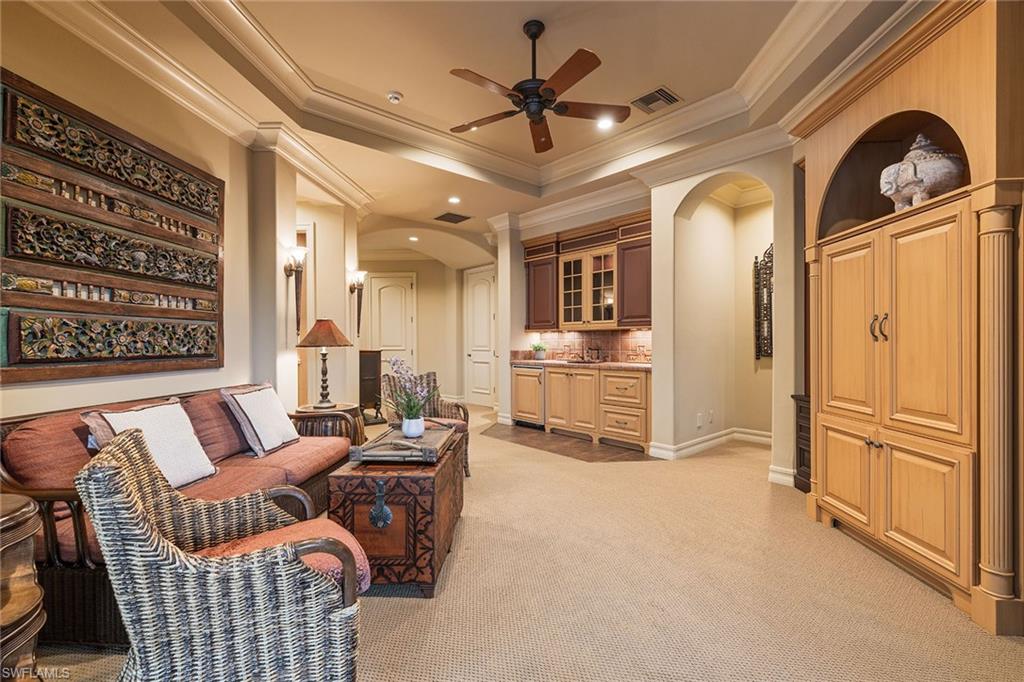 15167 Brolio Lane Naples, FL 34110 - Photo 24 of 50 a living room with furniture a fireplace and a chandelier