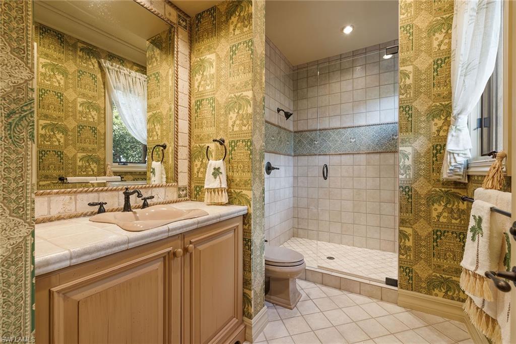 15167 Brolio Lane Naples, FL 34110 - Photo 28 of 50 a bathroom with a sink a toilet and shower