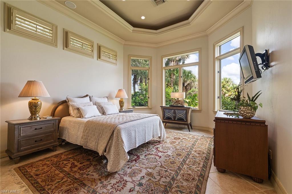 15167 Brolio Lane Naples, FL 34110 - Photo 32 of 50 a bedroom with a large bed and a window