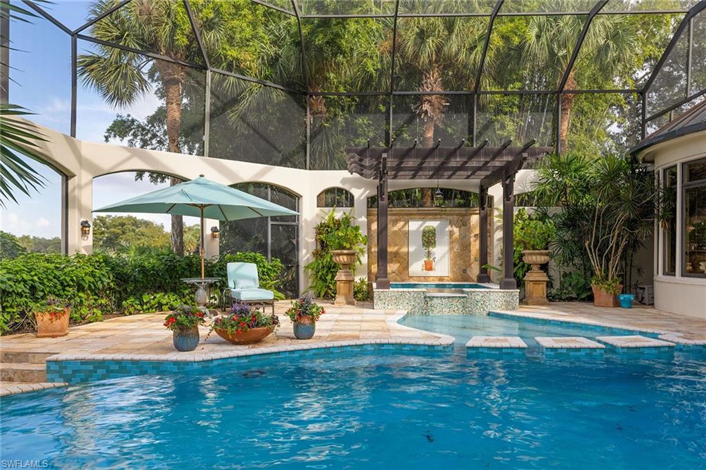 15167 Brolio Lane Naples, FL 34110 - Photo 38 of 50 a view of a fountain with a bench in patio