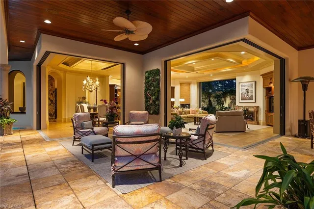 a living room with patio furniture and a floor to ceiling window