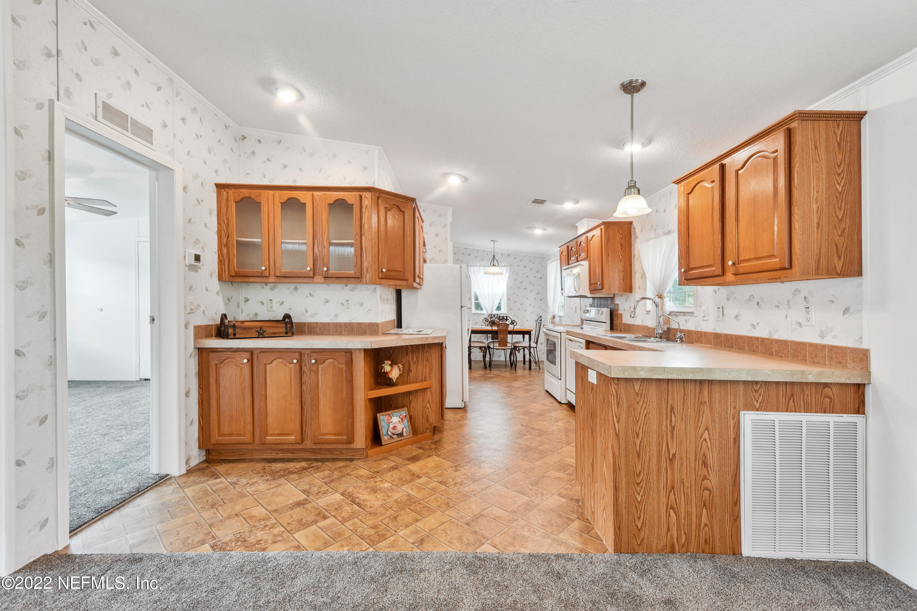 836 Halsema Road South Jacksonville, FL 32221 - Photo 14 of 31 a kitchen with a refrigerator a sink and cabinets