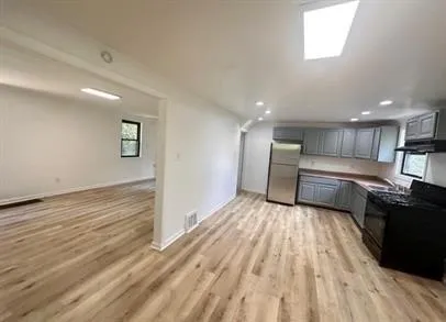 a view of kitchen with sink and refrigerator