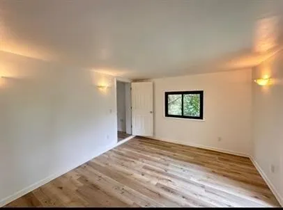 a view of a big room with wooden floor and windows