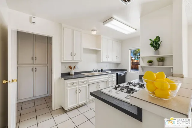 a kitchen with a stove a sink and a granite counter tops