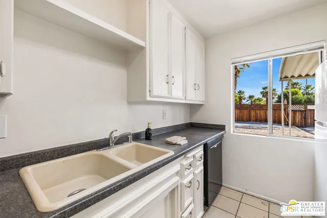 a kitchen view of a stove a faucet a chimney and a dining table