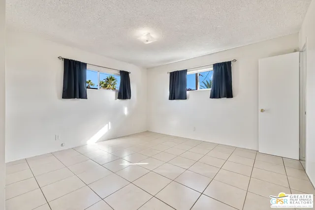 an empty room with windows and couch