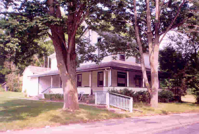 front view of a house with a large tree